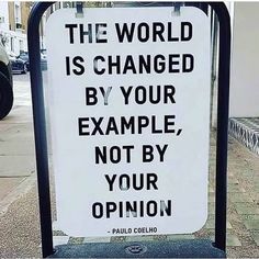 a sign that says the world is changed by your example, not by your opinion