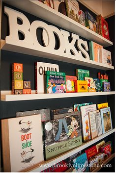 children's books are lined up on shelves in the library, with white letters above them