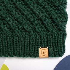 a green knitted hat with a wooden button