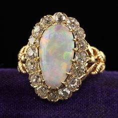 Beautiful Antique Victorian 18K Yellow Gold Natural Australian Opal Diamond Halo Ring. This gorgeous Victorian Australian opal diamond ring is crafted in 18k yellow gold. This ring features a gorgeous natural Australian opal in the center that has an incredible play of colors. The diamonds around the opal are chunky old mine cut stones. The ring is in great condition and sits low on the finger. Item #R2033 Metal: 18K Yellow Gold Weight: 5.1 Grams  Size: 6 1/2 Opal: Approximately 2.25 cts Diamonds: Approximately 2 cts Color: I Clarity: SI1 Measurements: Top of the ring measures 20.50 mm wide and band measures 2.42 mm wide. Measurements off the finger: 6.54 mm high Layaway: For your convenience, we will be happy to provide layaway payment options. Please contact us to work out a layaway plan Opal Ring Antique, Opal Diamond Ring, Diamond Halo Ring, Halo Diamond Ring, Australian Opal, Halo Ring, Halo Rings, Diamond Halo, Antique Victorian