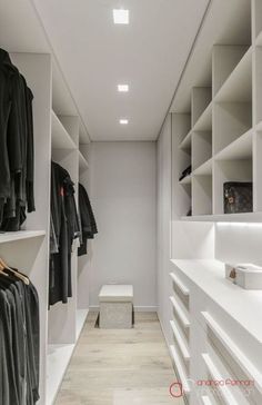 a walk in closet with white shelving and shelves