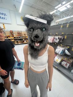 a person in a store with a dog mask on their head and another person standing next to him