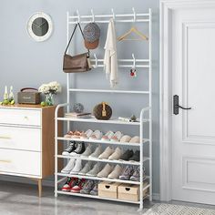 a white shoe rack filled with shoes next to a dresser and closet door in a room