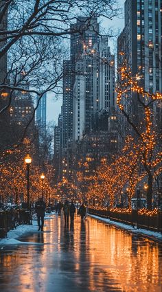 people are walking down the street in the city at night with christmas lights on trees