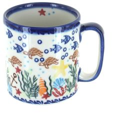 a blue and white coffee mug with sea animals on it's side, sitting in front of a white background