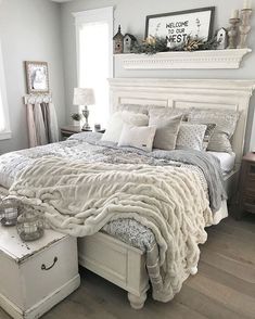 a white bed sitting in a bedroom on top of a hard wood floor next to a window