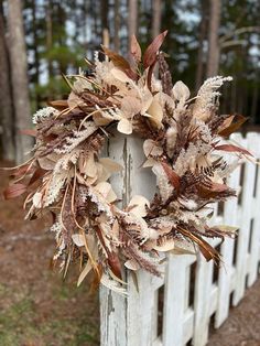 a wreath is hanging on the side of a white fence