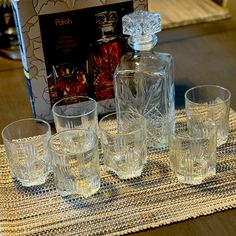 an assortment of glassware sitting on top of a table next to a boxed book