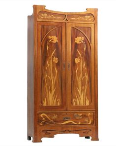 an old wooden armoire with floral designs on the front and side panels, sitting against a white background