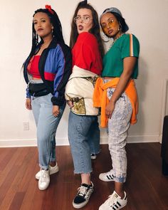 three women standing next to each other in front of a wall with their mouths open