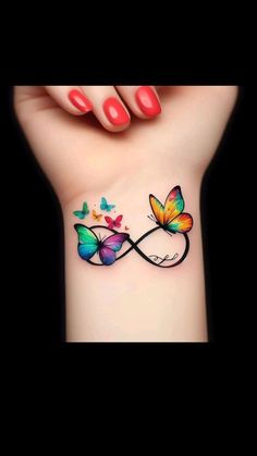 a woman's wrist with butterflies on it and the word love written in butterfly tattoos