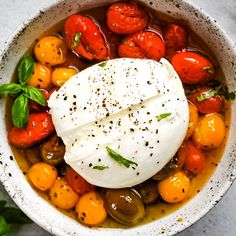 a bowl filled with tomatoes, olives and mozzarella