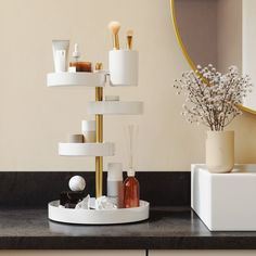 a bathroom counter with various items on it and a mirror in the corner behind it