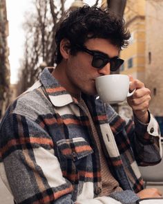 a man sitting down drinking out of a cup