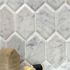 a pair of shoes sitting on the floor next to a wooden box and marble tiles