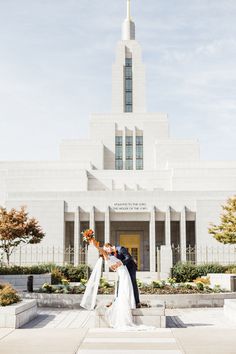 a bride and groom kiss in front of the mormon temple on their wedding day,