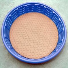 a blue plastic bowl sitting on top of a cement floor