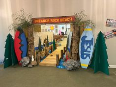 an entrance to a rock beach with surfboards and trees on the ground in front of it