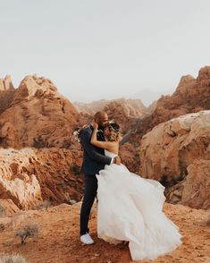 a bride and groom embracing in the desert