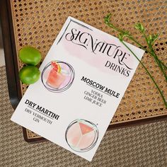 the menu for signature drinks is displayed on a table with limes and watermelon