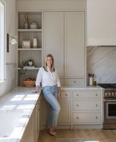 a woman leaning on the counter in a kitchen