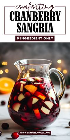 a pitcher filled with cranberry sangria on top of a table