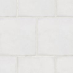 an orange cat laying on top of a white tile floor