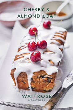 cherry and almond loaf with white icing on a plate