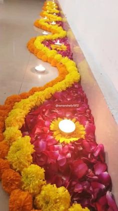 a long row of flowers with candles in the middle