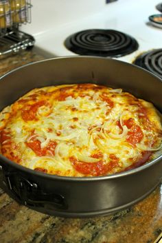 a pizza sitting in a pan on top of a stove next to some burners