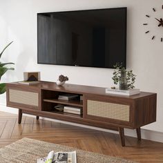 a large flat screen tv mounted to the side of a wooden entertainment center in a living room