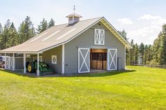 a tractor parked in front of a gray barn