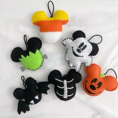 several mickey mouses and pumpkins are on a white sheet with black, orange, and green felt