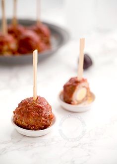 small appetizers with toothpicks in them sitting on a white counter top