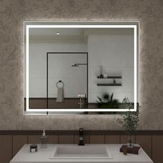 a bathroom with a sink, mirror and lights on the wall above it's counter