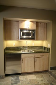 an empty kitchen with stainless steel appliances and wood cabinets