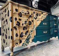 an old dresser has been painted with leopard spots and gold paint on the sideboard