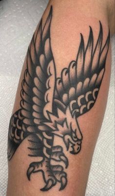 a black and white photo of a tattoo on someone's arm with an eagle