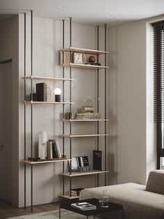 a living room filled with furniture and a tall book shelf next to a window covered in blinds