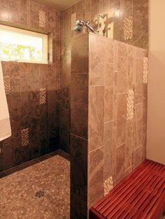 a tiled shower with a bench in the corner