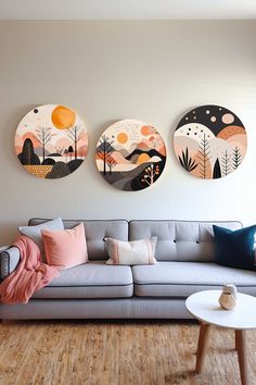 three circular paintings hang on the wall above a couch