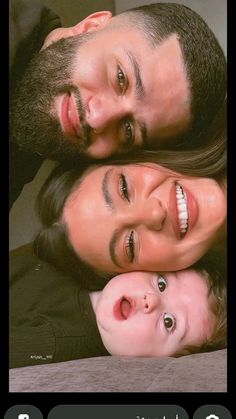 two adults and a child are smiling at the camera with their heads close to each other