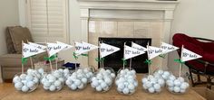 a table topped with vases filled with white and green eggs next to a fireplace