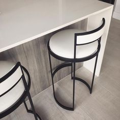 two white chairs sitting on top of a counter