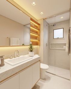 a bathroom with a sink, toilet and shower stall in the background is illuminated by recessed lighting