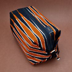 "Finally, a wash bag big enough to hold all your essentials.! Handmade in small batches in the UK, the precise placement of wax prints will always differ between each one made. Materials: Ankara, also known as African Prints, African Wax Prints, Holland Wax or Dutch Wax is made from 100% Cotton.  Black zipper with matching wax print zip pull. 100% coated black nylon lining. Dimensions: 29.5 x 16.5 x 14.5cm (11 x 6.5 x 6\") Care: Wipe clean recommended. If a deeper clean is later required, machine wash cold or below 30 degrees Celsius to maintain vibrancy of your prints. Reshape whilst damp & air dry. TOP TIP These make perfect gift sets when paired with our Cosmetic Bags: https://www.etsy.com/uk/listing/1224286116/african-wax-print-cosmetic-bag-lolly?click_key=80a96180c14acddf0bb13b85a9152 Ankara Accessories, African Products, African Gifts, Toiletry Kit, Dopp Kit, African Prints, African Wax Print, Wash Bag, Wax Print