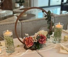 the table is set with candles and flowers in glass vases, along with napkins