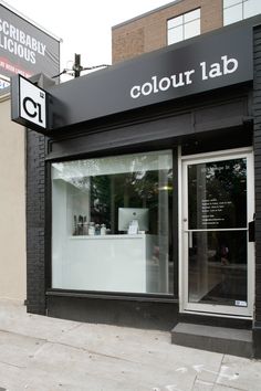 a black and white store front on the side of a building with large windows that say,'color lab '