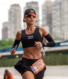 a woman running in a race with her arm wrapped around her waist and sunglasses on