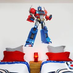 a bedroom with a bed and a wall decal that has a transformer on it